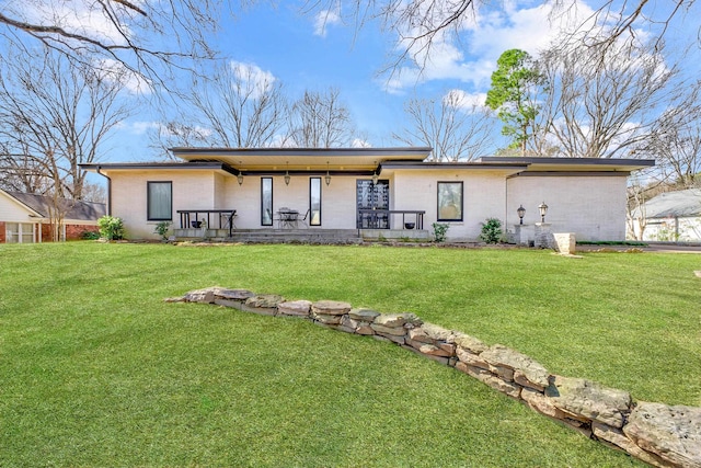 back of house with brick siding and a lawn