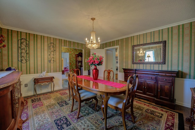 dining area with a chandelier, crown molding, and wallpapered walls