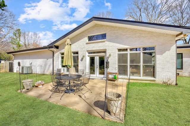 back of house featuring a yard, french doors, a patio area, and brick siding