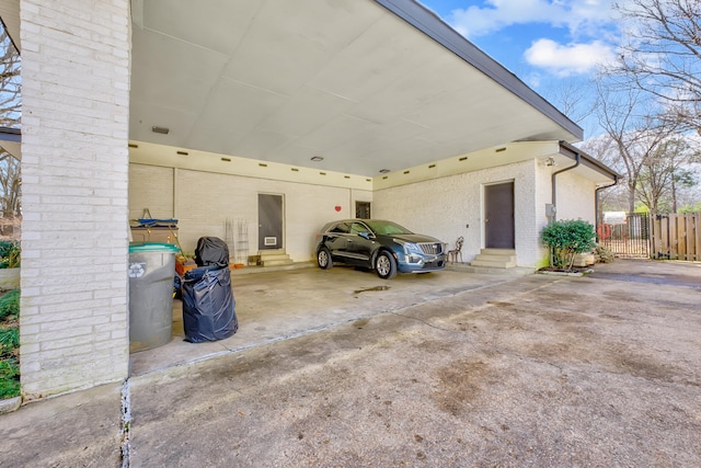 garage featuring driveway and fence