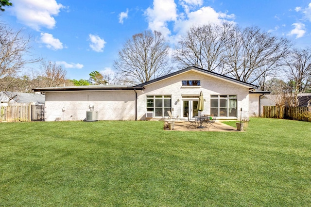 rear view of house featuring a yard, fence, a patio, and french doors