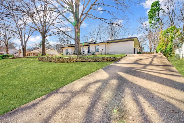 view of front of house featuring driveway, an attached garage, and a front yard