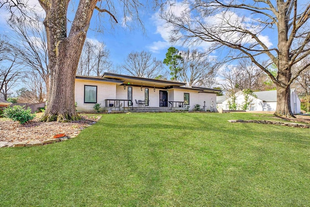 view of front of property featuring a porch, a front yard, fence, and stucco siding