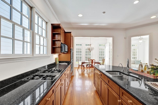 kitchen with black electric stovetop, a sink, open shelves, brown cabinetry, and dark stone countertops