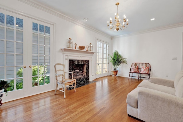 living area with a premium fireplace, recessed lighting, wood finished floors, and crown molding