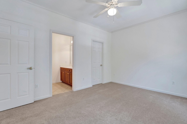 unfurnished bedroom with connected bathroom, light colored carpet, a ceiling fan, baseboards, and crown molding