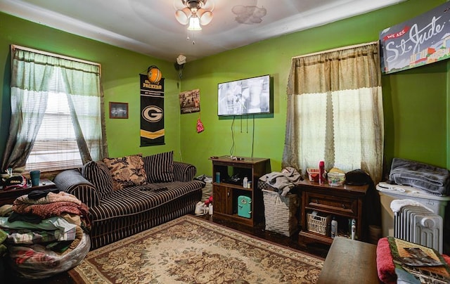 living area with a ceiling fan and wood finished floors