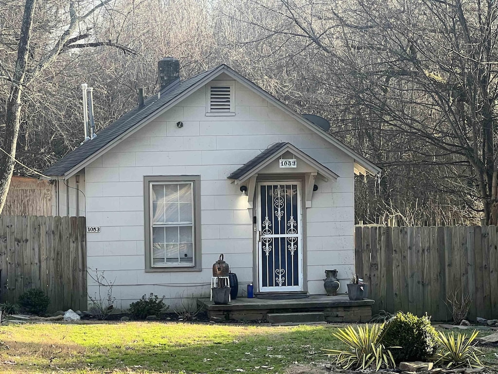 bungalow-style house with fence and a front lawn