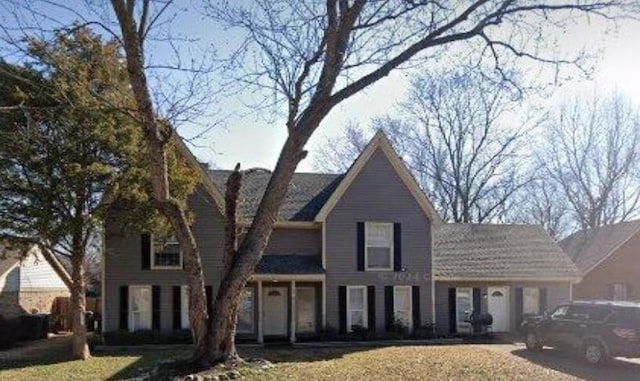 traditional-style house featuring a front lawn