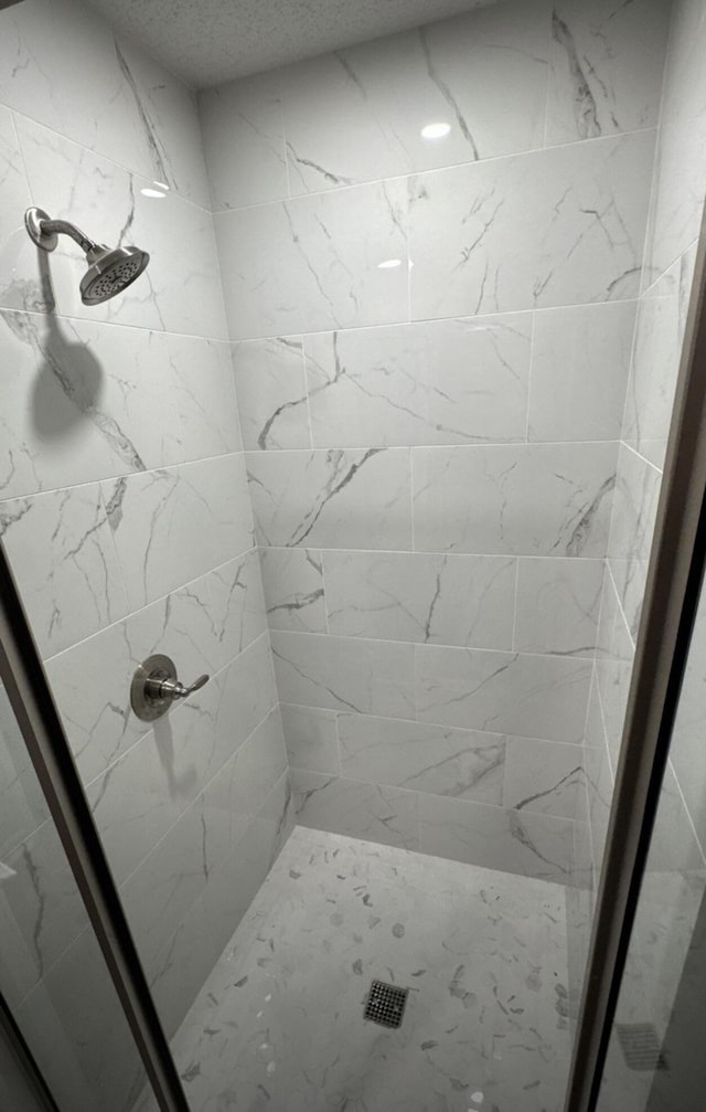 full bath featuring a shower stall and a textured ceiling