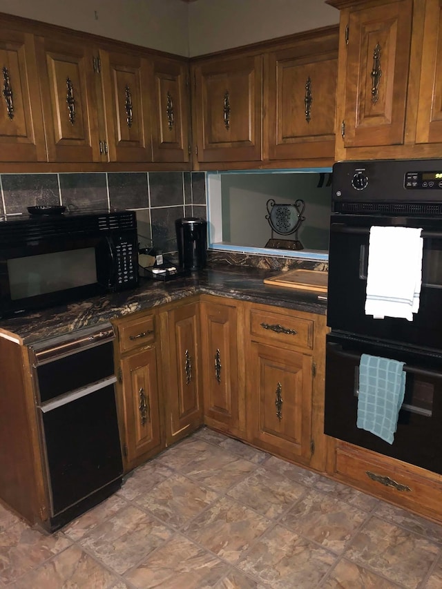 kitchen with black appliances, tasteful backsplash, dark stone countertops, and brown cabinets