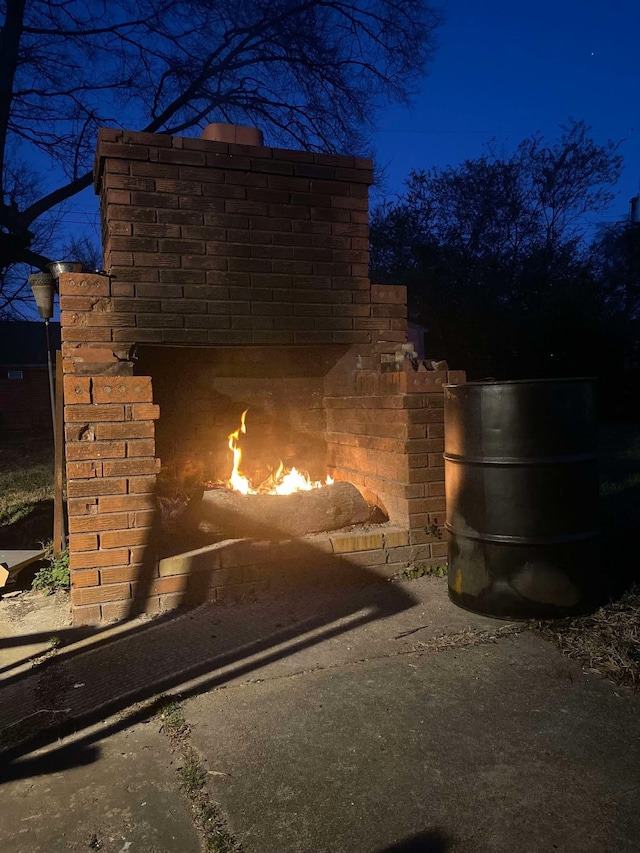 exterior space with a warm lit fireplace