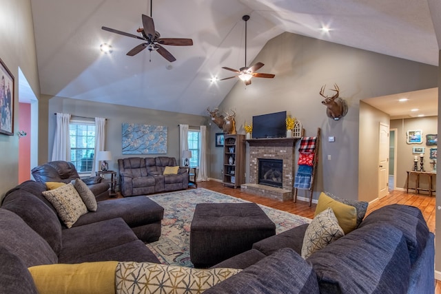 living room with light wood finished floors, baseboards, a brick fireplace, and high vaulted ceiling