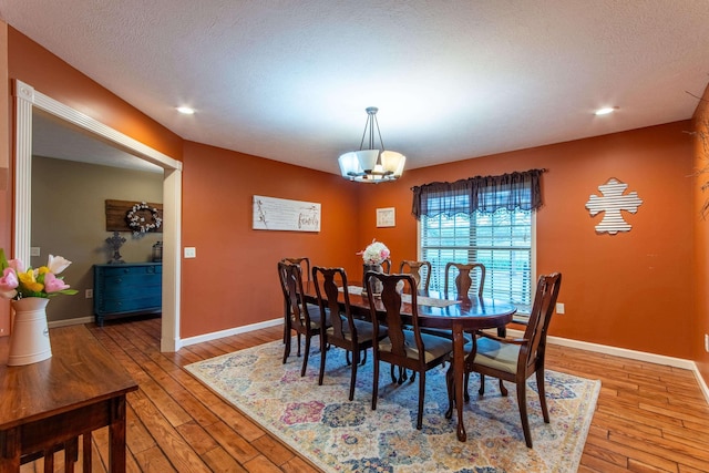 dining area with light wood-style floors, baseboards, and an inviting chandelier