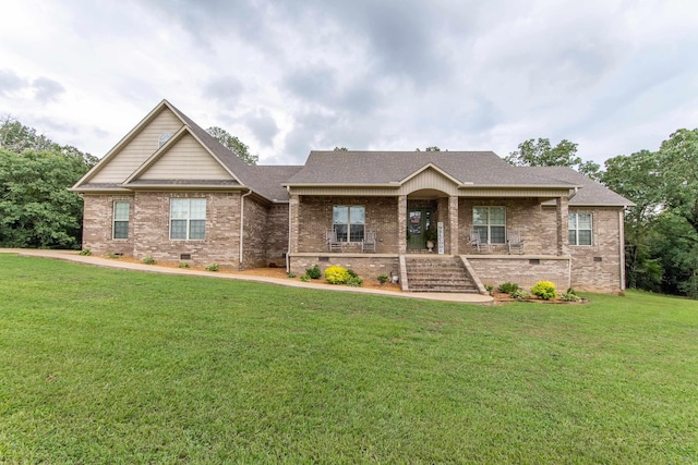 craftsman house with a porch, a front yard, crawl space, and brick siding