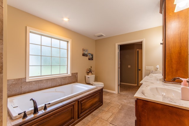 bathroom featuring a garden tub, double vanity, visible vents, toilet, and a sink