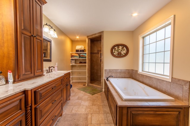 full bathroom with a shower stall, stone finish flooring, vanity, and a whirlpool tub