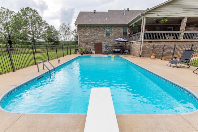 view of swimming pool featuring a diving board, a patio, fence, and a fenced in pool