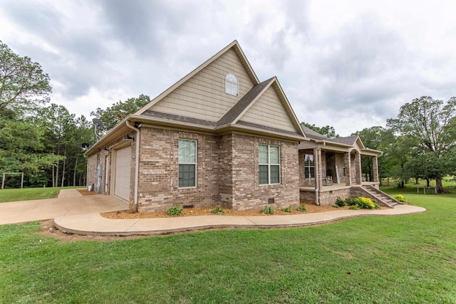 view of side of home with brick siding, a yard, a porch, concrete driveway, and crawl space