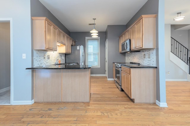 kitchen with visible vents, appliances with stainless steel finishes, light wood-style floors, light brown cabinets, and a peninsula