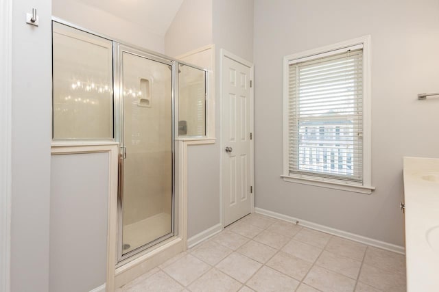 full bathroom featuring a stall shower, tile patterned flooring, lofted ceiling, and baseboards