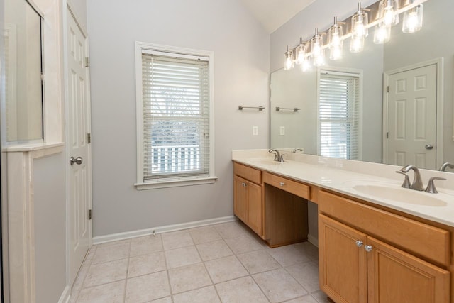 bathroom with vaulted ceiling, double vanity, a sink, and tile patterned floors