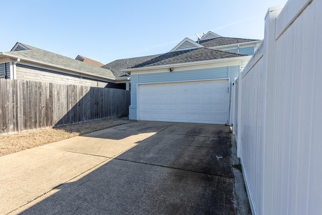 garage with driveway and fence