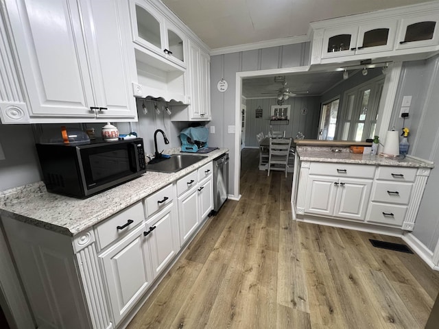 kitchen featuring black microwave, a sink, white cabinetry, light wood-style floors, and dishwasher