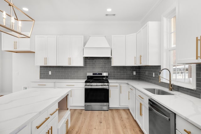 kitchen with a sink, stainless steel appliances, custom exhaust hood, and white cabinetry