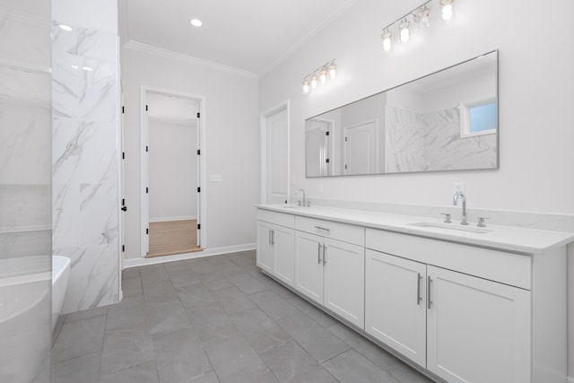 full bath featuring a freestanding bath, double vanity, a sink, and crown molding