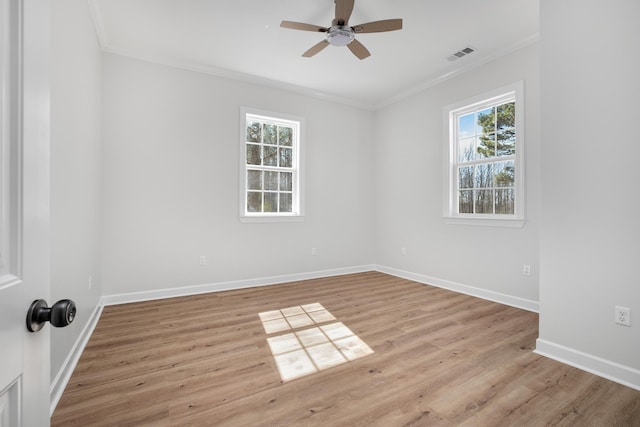 unfurnished room with a ceiling fan, baseboards, light wood-style floors, visible vents, and crown molding