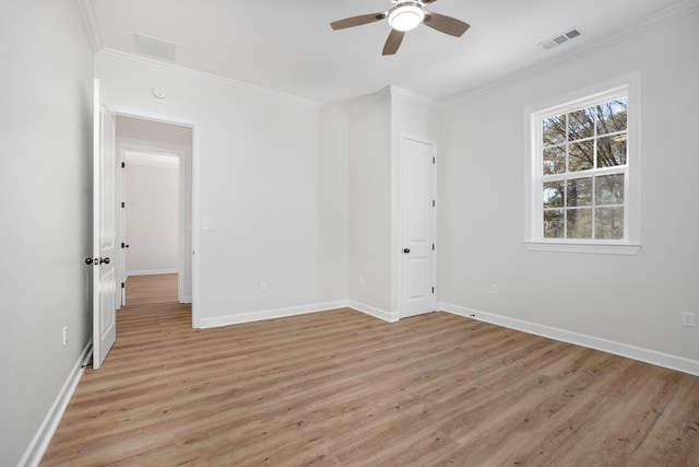 unfurnished bedroom featuring ornamental molding, visible vents, light wood-style flooring, and baseboards