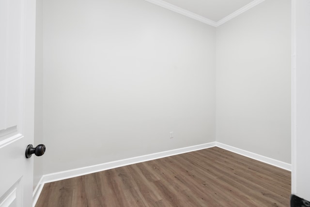 spare room featuring baseboards, dark wood finished floors, and crown molding