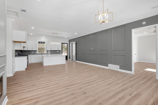 kitchen featuring open floor plan, white cabinetry, and pendant lighting