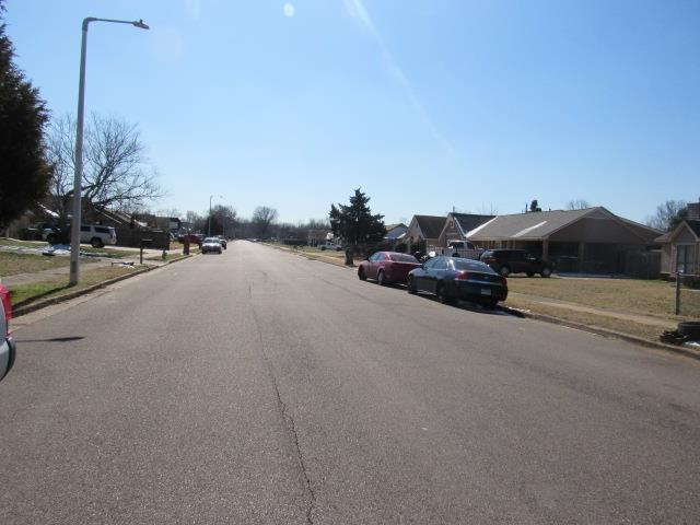 view of road with street lighting, a residential view, curbs, and sidewalks