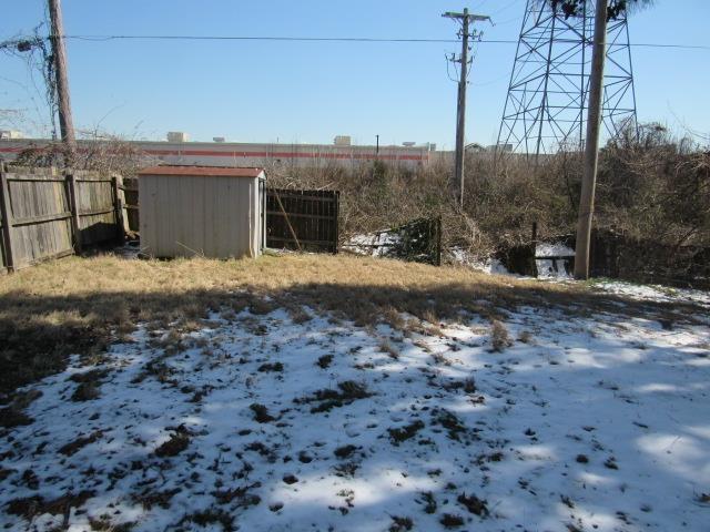 view of yard with a storage shed, fence, and an outdoor structure