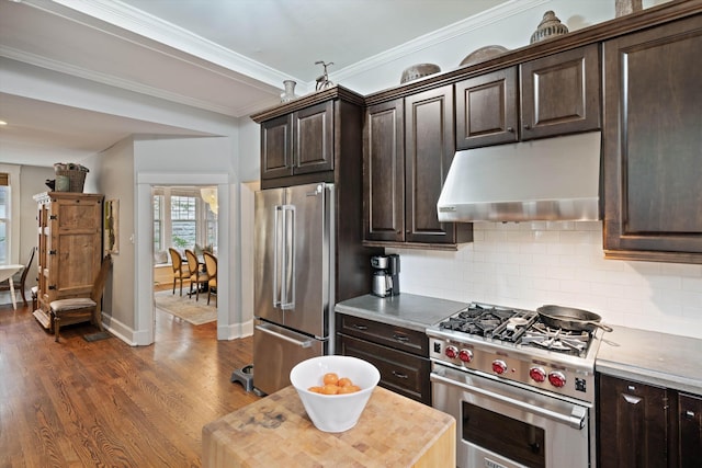 kitchen with dark brown cabinetry, under cabinet range hood, and high quality appliances