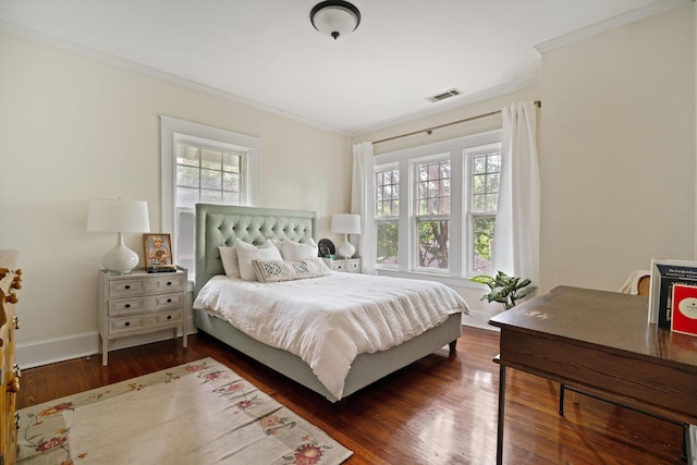 bedroom featuring dark wood-type flooring, multiple windows, visible vents, and crown molding