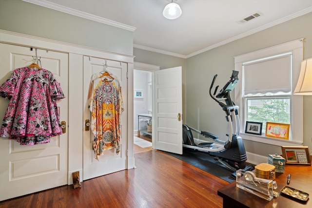 workout room featuring baseboards, visible vents, dark wood finished floors, and ornamental molding