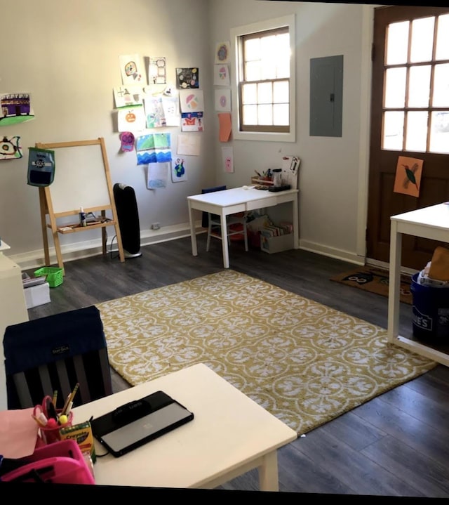 office area with electric panel, dark wood finished floors, and baseboards