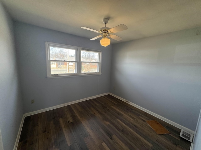 spare room featuring a ceiling fan, visible vents, baseboards, and dark wood-type flooring