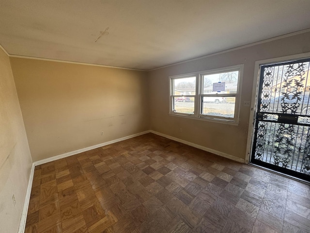 spare room with ornamental molding and baseboards