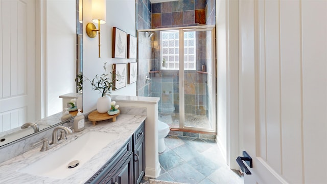 bathroom featuring a shower stall, toilet, and vanity