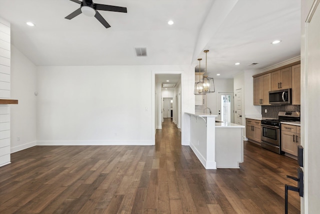 kitchen featuring a breakfast bar, decorative light fixtures, a peninsula, stainless steel appliances, and light countertops