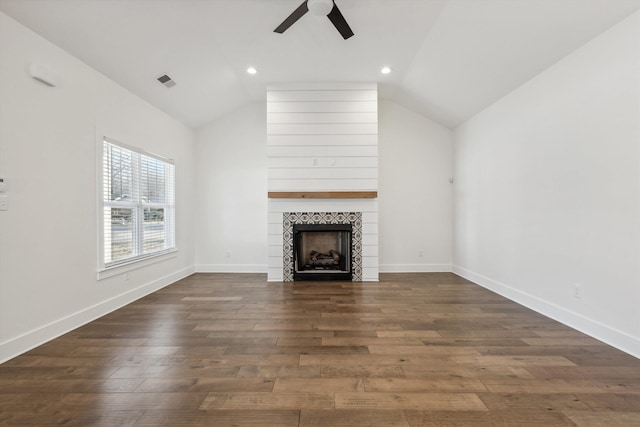 unfurnished living room with baseboards, visible vents, dark wood-style floors, vaulted ceiling, and a fireplace