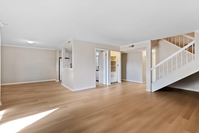 interior space featuring crown molding, visible vents, light wood-style floors, baseboards, and stairs