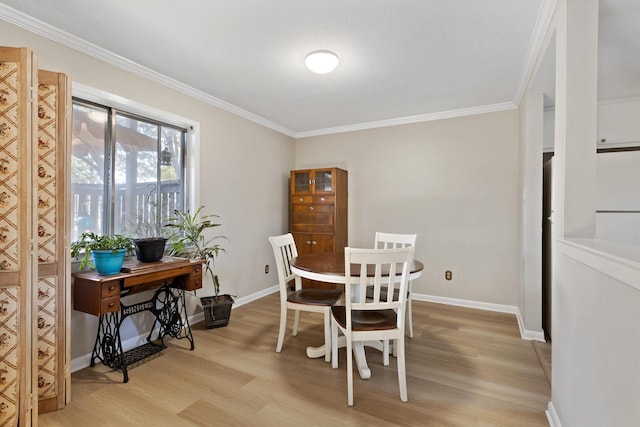 dining space with light wood-type flooring, crown molding, and baseboards