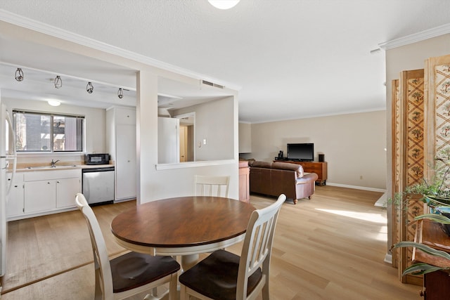 dining room featuring visible vents, ornamental molding, light wood-style flooring, and baseboards