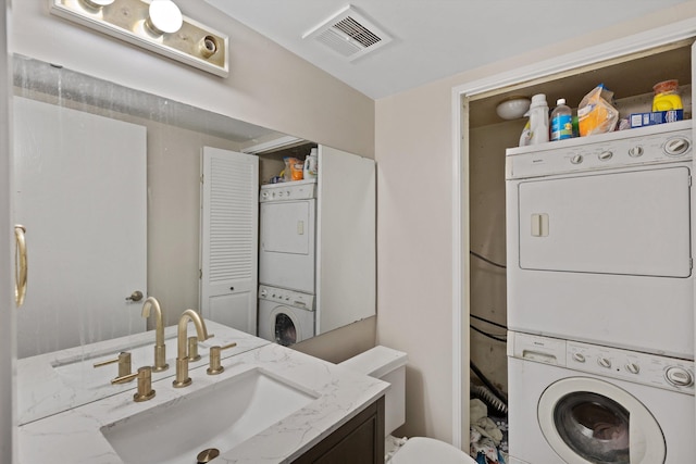 laundry area featuring stacked washer / dryer, laundry area, visible vents, and a sink