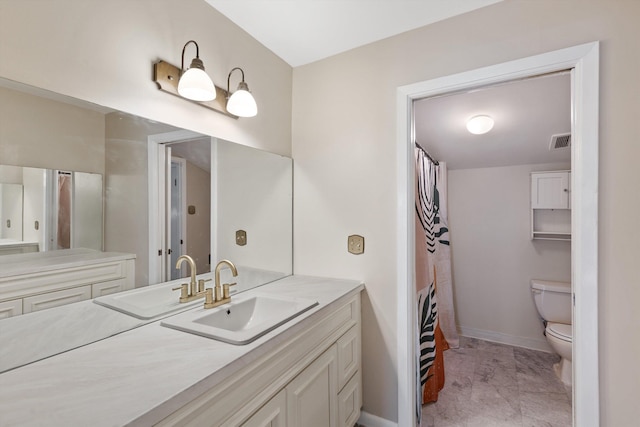 bathroom featuring toilet, vanity, visible vents, and baseboards